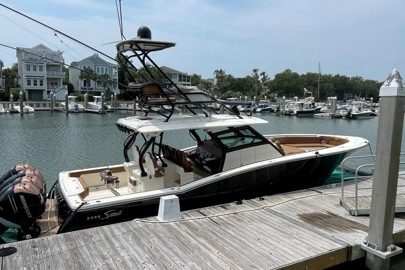 Slide: The Image of 2020 Scout 420 LXF luxury boat docked at a marina. - 1