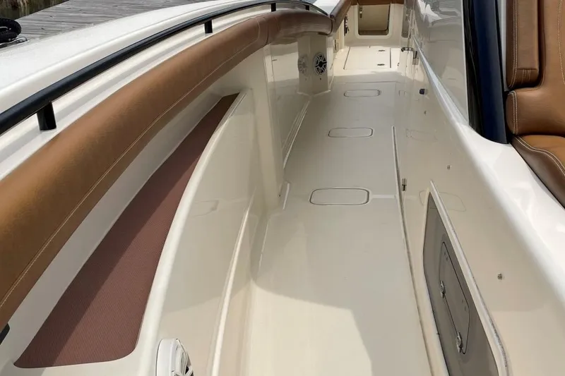 Slide: The Image of 2020 Scout 420 LXF boat deck with tan seating and storage compartments. - 10
