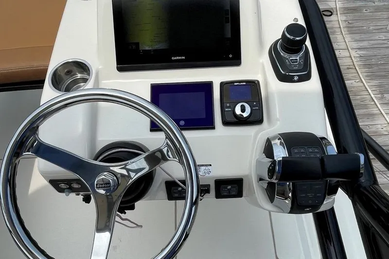 Slide: The Image of 2020 Scout 420 LXF boat helm with steering wheel, Garmin display, and control panel. - 19