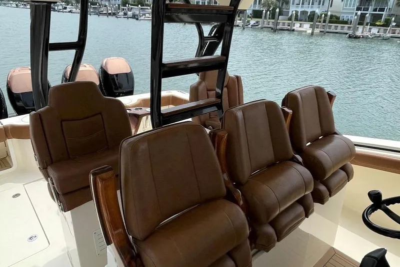 Slide: The Image of 2020 Scout 420 LXF boat interior with brown leather seats and waterfront view. - 36