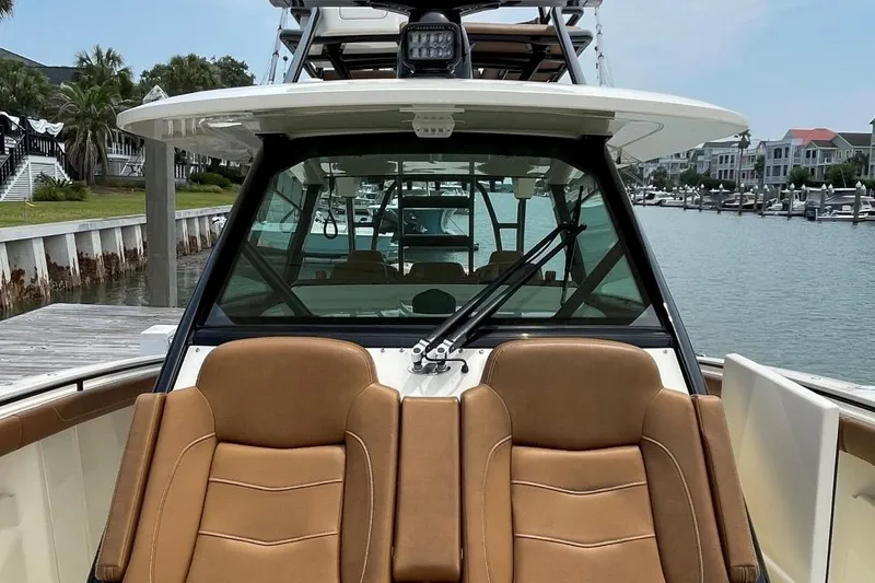 Slide: The Image of 2020 Scout 420 LXF boat with tan seats docked at a marina. - 9