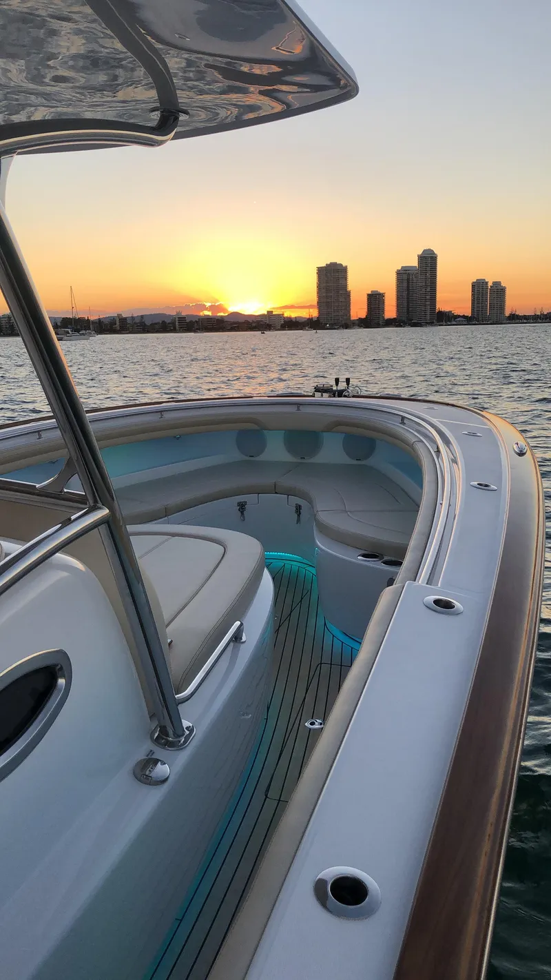 Slide: The Image of 2025 Mag Bay 33 CC boat at sunset with city skyline in the background. - 14