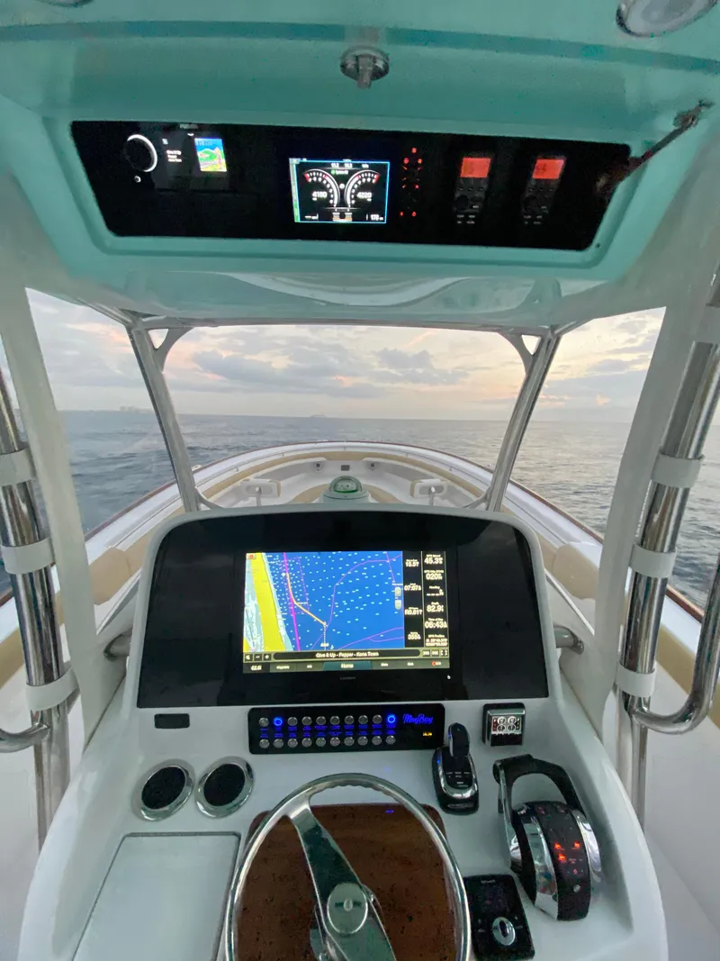 Slide: The Image of 2025 Mag Bay 33 CC boat dashboard with navigation system and ocean view. - 5