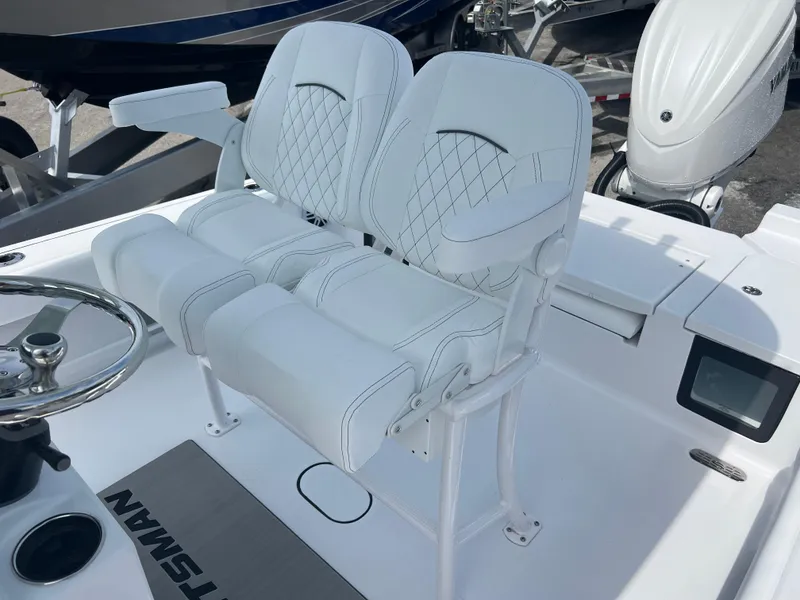 Slide: The Image of 2024 Sportsman 247 OE boat with dual white cushioned seats and steering wheel. - 12