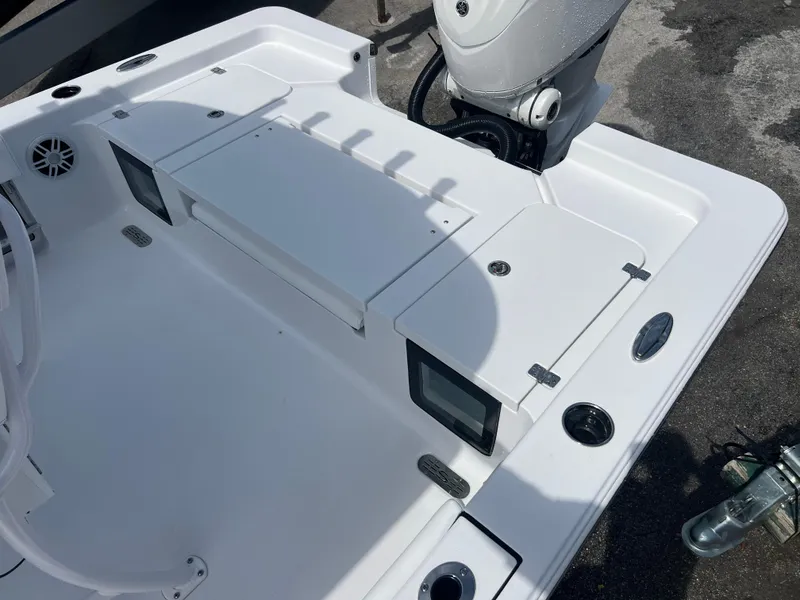 Slide: The Image of 2024 Sportsman 247 OE boat deck with storage compartments and motor. - 13