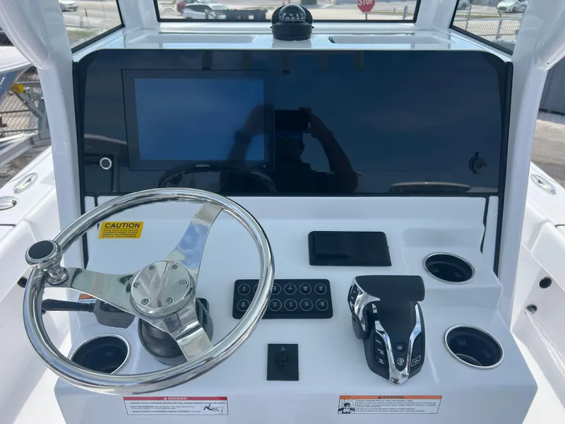Slide: The Image of 2024 Sportsman 247 OE boat dashboard with steering wheel, touchscreen display, and control panel. - 8