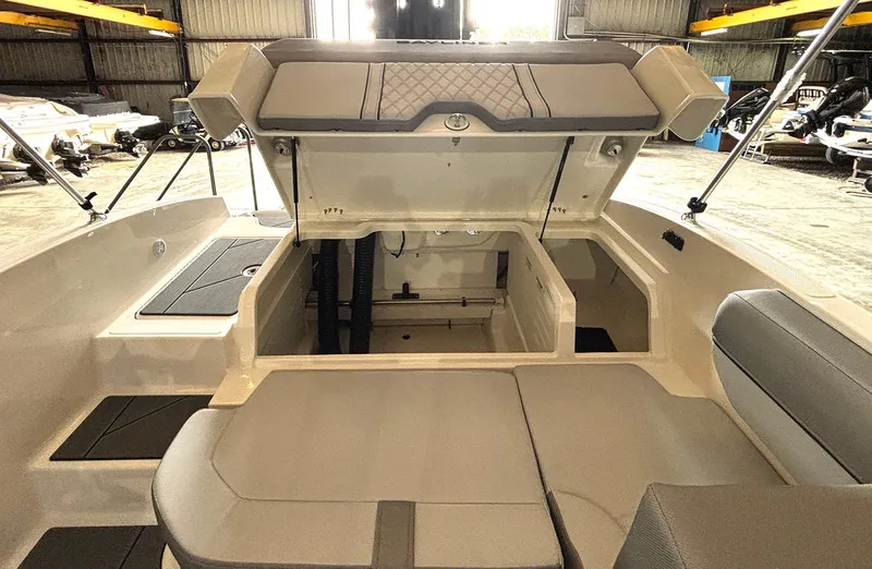 Slide: The Image of 2024 Bayliner DX2000 boat interior with open storage compartments in a warehouse. - 15