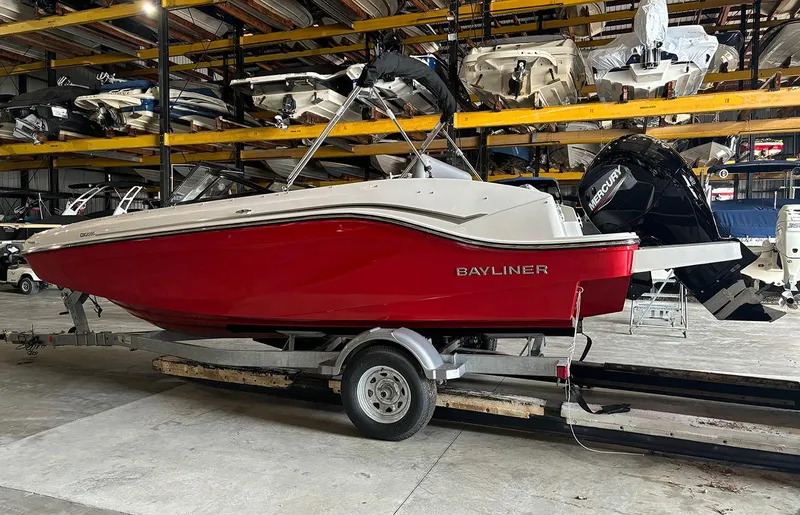 Slide: The Image of 2024 Bayliner DX2000 boat in red, stored indoors on a trailer. - 2