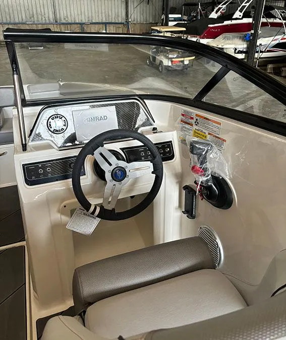Slide: The Image of 2024 Bayliner DX2000 boat cockpit with steering wheel and Simrad display. - 9