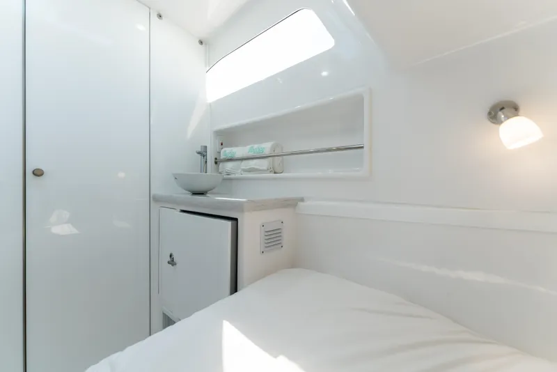 Slide: The Image of Interior of 2025 Mag Bay 43 CC boat, featuring a modern, white bathroom. - 25