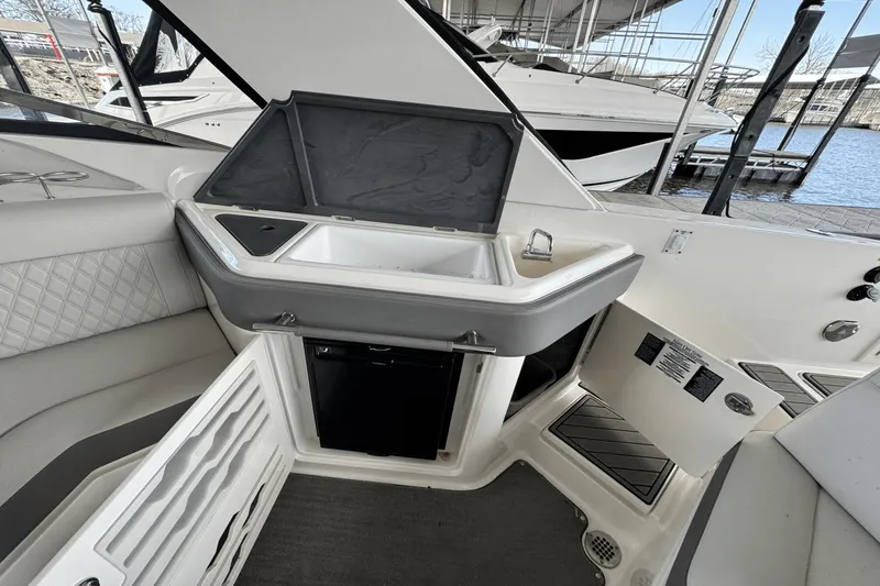 Slide: The Image of Interior of 2021 Sea Ray 310 SLX boat featuring a compact kitchenette with sink and storage. - 19