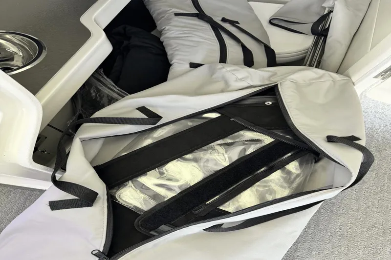 Slide: The Image of Storage compartment with bags on a 2021 Sea Ray 310 SLX boat. - 23