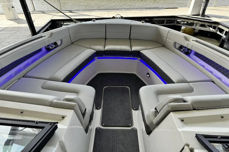 Slide: The Image of 2021 Sea Ray 310 SLX boat interior with luxurious seating and ambient blue lighting. - 25