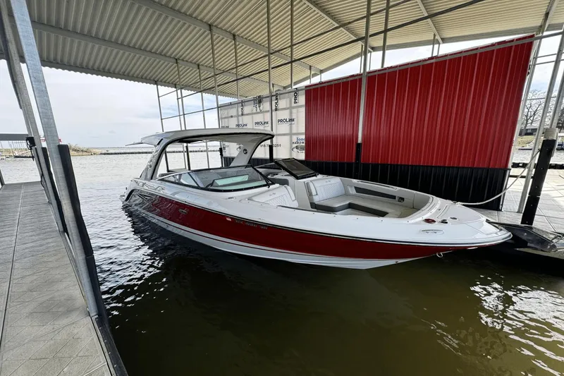 Slide: The Image of 2021 Sea Ray 310 SLX boat docked under a covered marina. - 27