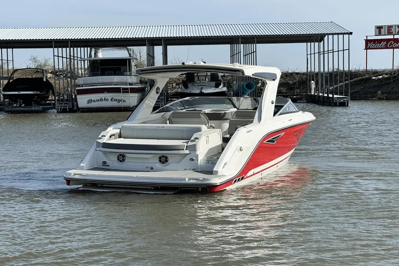 Slide: The Image of 2021 Sea Ray 310 SLX boat in water near dock, featuring sleek red and white design. - 5