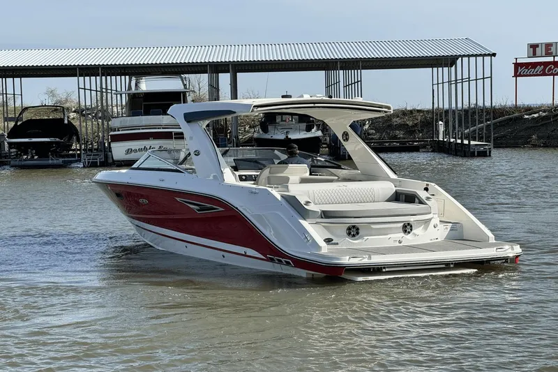 Slide: The Image of 2021 Sea Ray 310 SLX boat in marina, featuring sleek red and white design. - 7