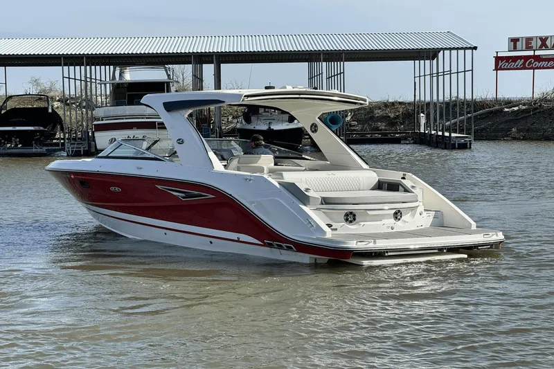 Slide: The Image of 2021 Sea Ray 310 SLX boat in water near dock, red and white design. - 8