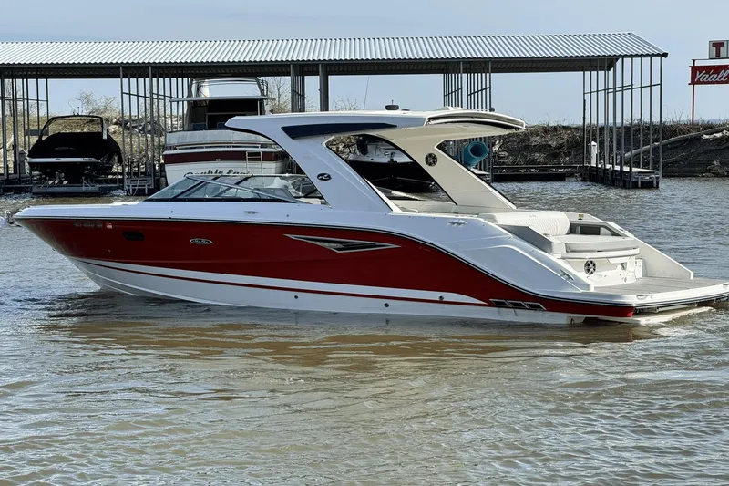 Slide: The Image of 2021 Sea Ray 310 SLX boat with red and white design docked on the water. - 9