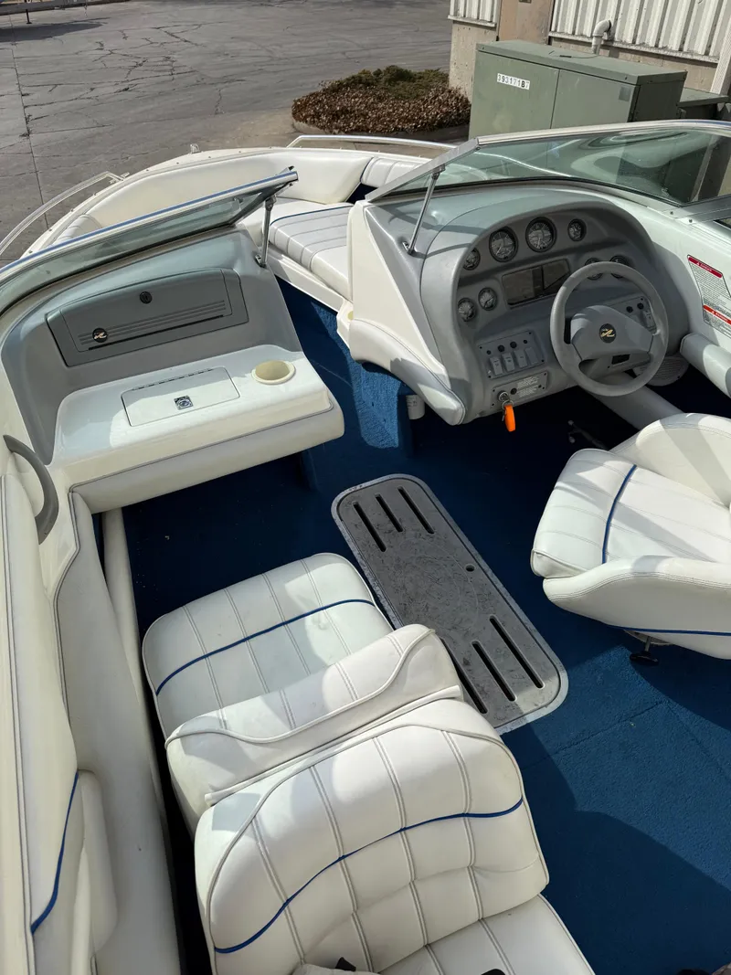 Slide: The Image of Interior of a 1995 Sea Ray 180 BR boat with white seating and blue carpet. - 4