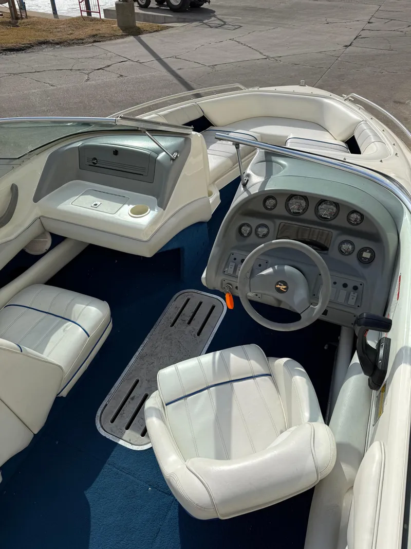 Slide: The Image of Interior of a 1995 Sea Ray 180 BR boat with white seating and dashboard. - 5