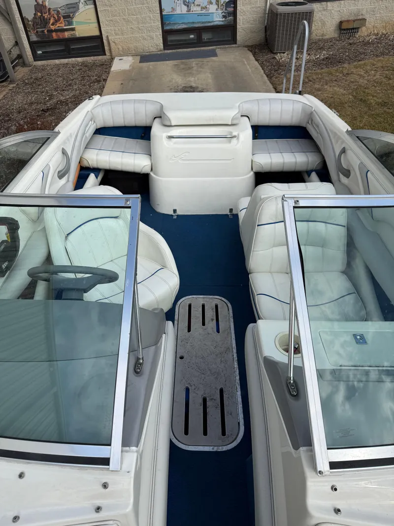 Slide: The Image of 1995 Sea Ray 180 BR boat interior with white seating and blue carpet. - 7