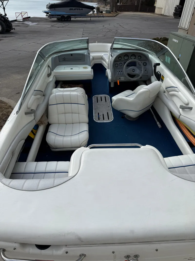 Slide: The Image of 1995 Sea Ray 180 BR boat interior with white seating and blue carpet. - 8