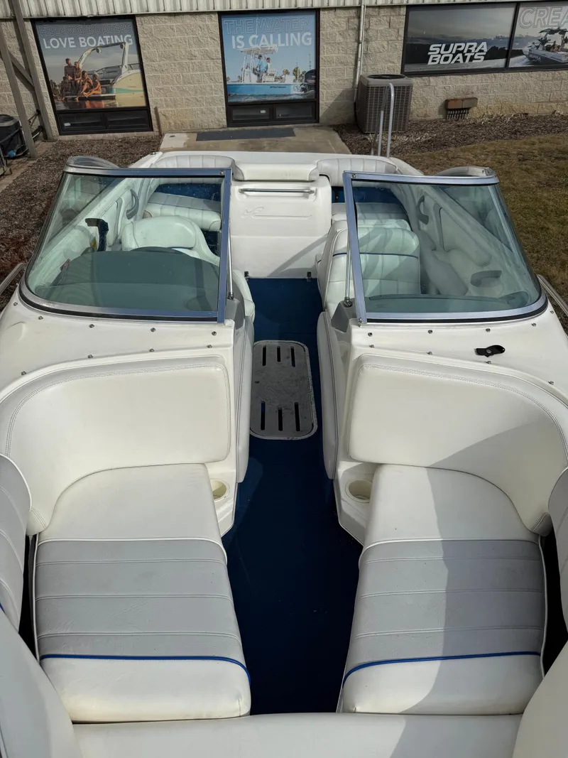 Slide: The Image of 1995 Sea Ray 180 BR boat interior with white seating and blue flooring. - 9