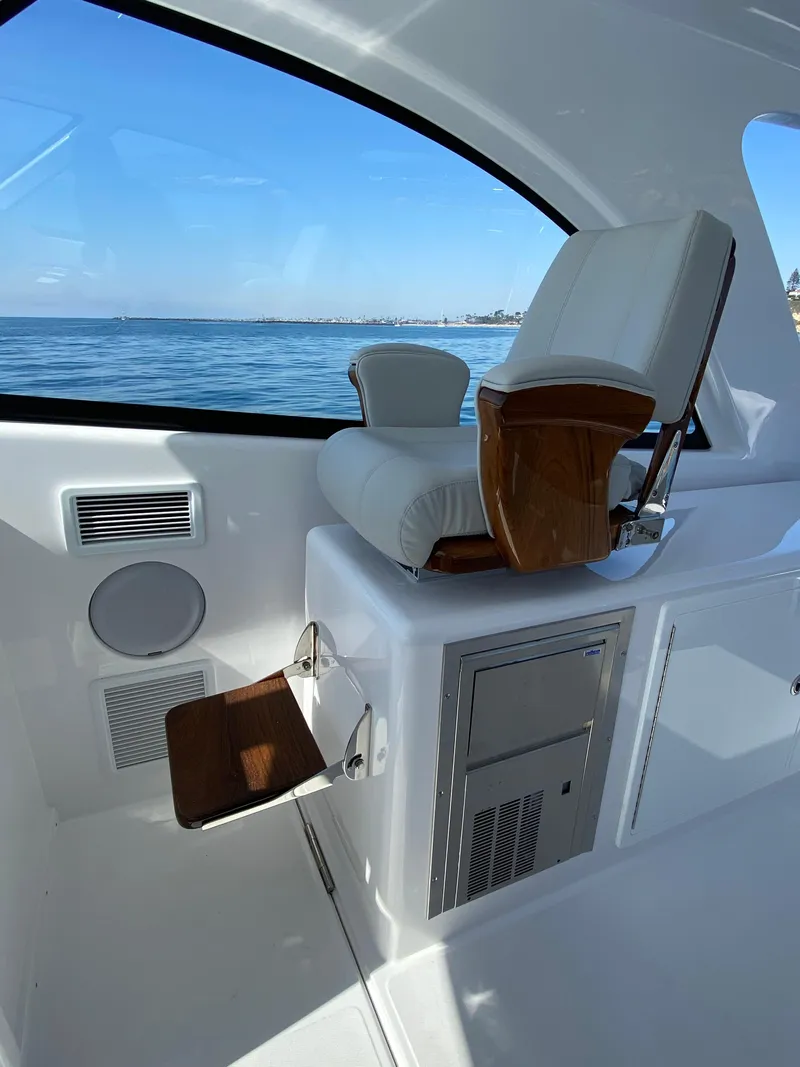 Slide: The Image of 2025 Mag Bay 42 yacht interior with white leather seating and ocean view. - 14
