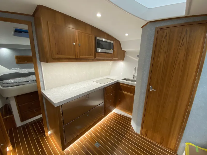 Slide: The Image of Modern kitchen area in 2025 Mag Bay 42 yacht with wood cabinetry and sleek countertops. - 23