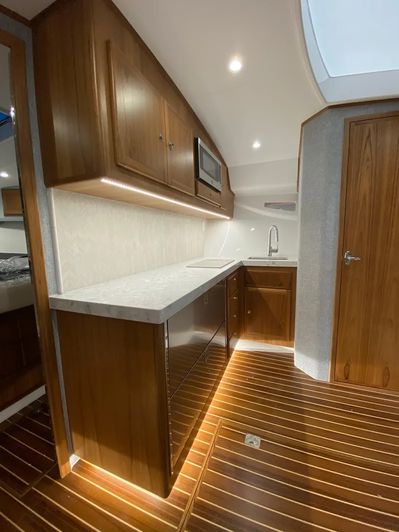 Slide: The Image of Modern kitchen area in 2025 Mag Bay 42 yacht with wooden cabinetry and flooring. - 24