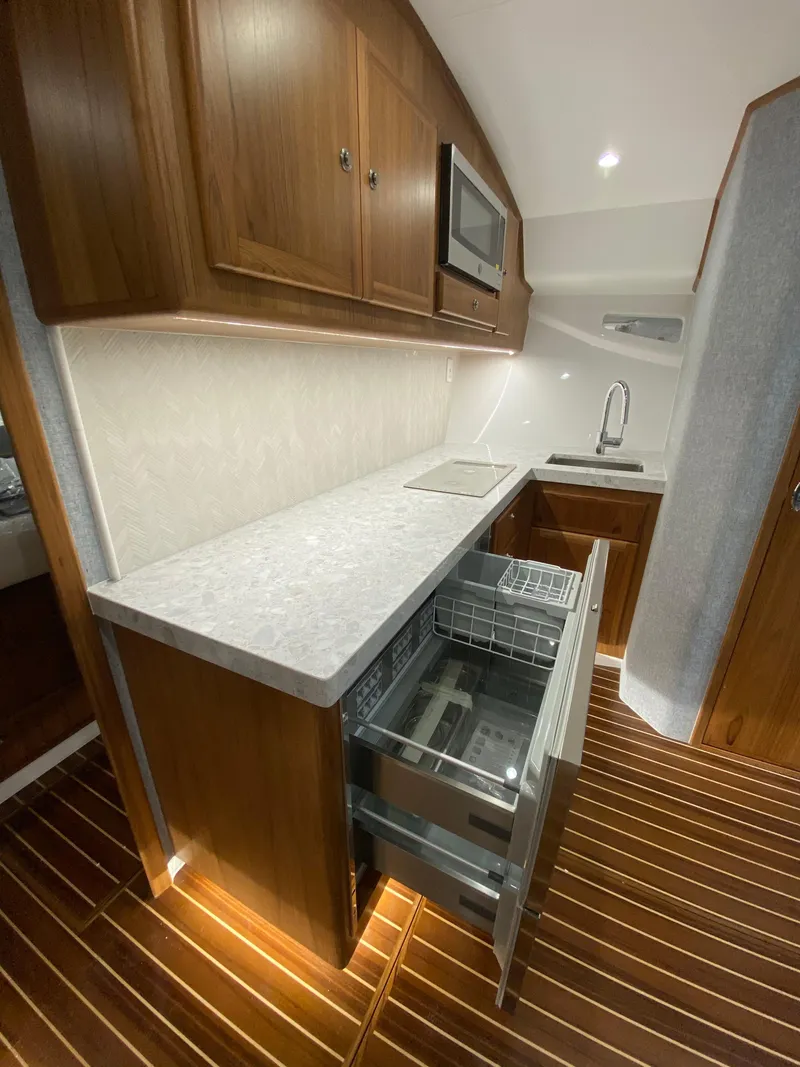 Slide: The Image of Modern kitchen area in 2025 Mag Bay 42 yacht with wood cabinetry and built-in appliances. - 25
