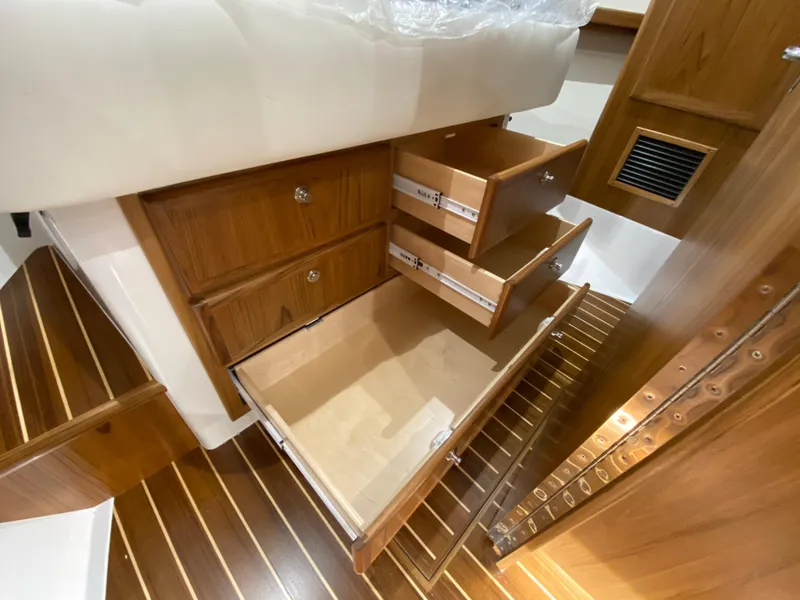 Slide: The Image of Mag Bay 42 (2025) yacht interior with open wooden drawers and striped flooring. - 26