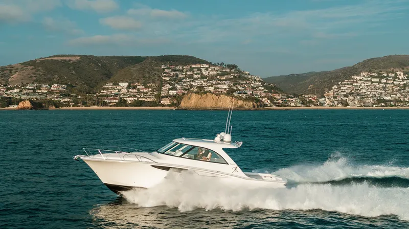 Slide: The Image of 2025 Mag Bay 42 yacht cruising on the ocean with coastal hills in the background. - 3