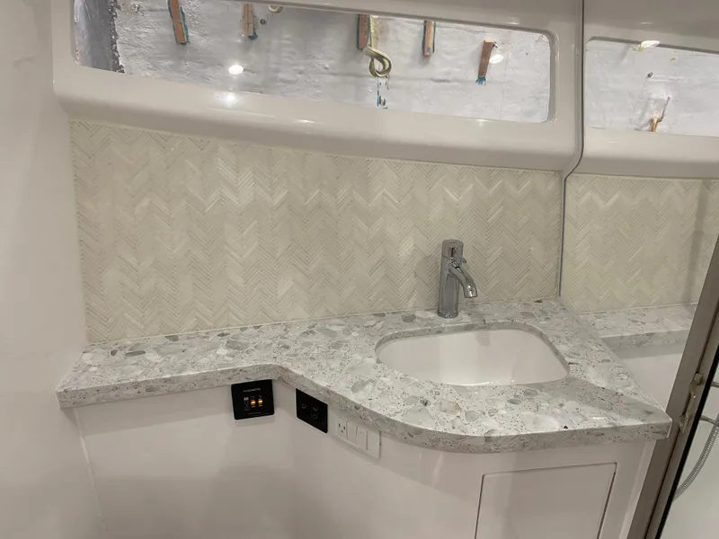 Slide: The Image of 2025 Mag Bay 42 yacht interior sink with marble countertop and modern faucet. - 32