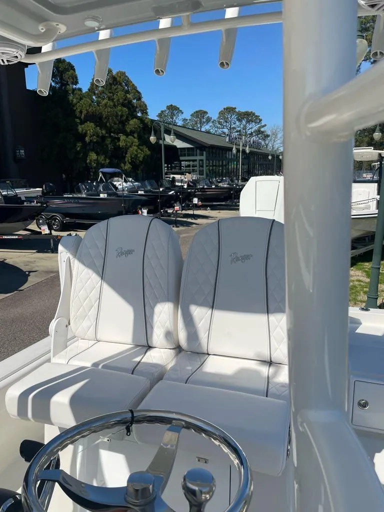 Slide: The Image of 2024 Ranger 2510 Bay boat with white leather seats and steering wheel. - 3