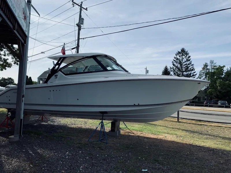 The Image of 2018 Pursuit DC 295 Dual Console boat on stands, side view. - 0
