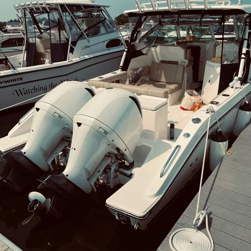 Slide: The Image of 2018 Pursuit DC 295 Dual Console boat docked with twin engines. - 1