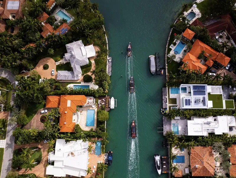 Slide: The Image of Aerial view of luxury waterfront homes and boats on a canal, featuring Skipper-BSK 38, 2024 model. - 16