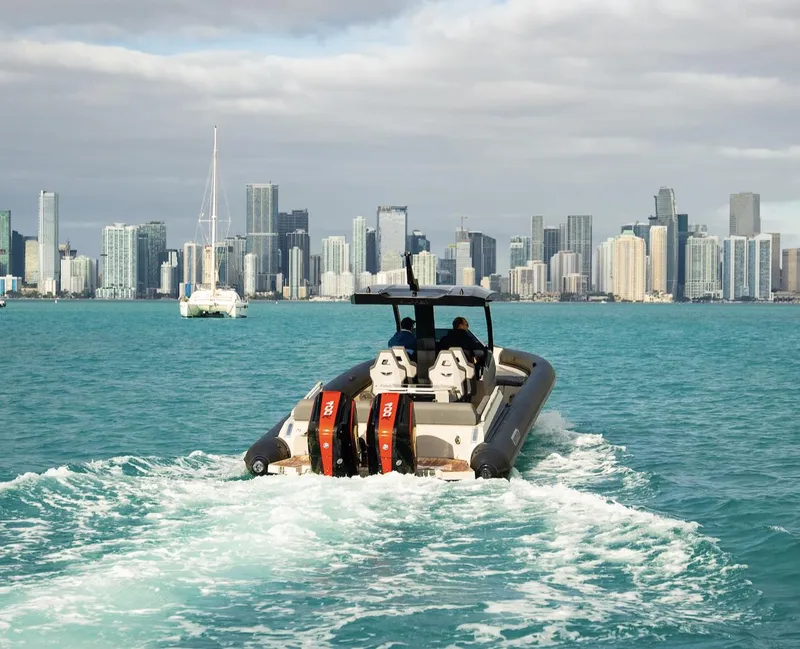 Slide: The Image of Skipper-BSK 38 boat cruising near a city skyline, 2024 model. - 21