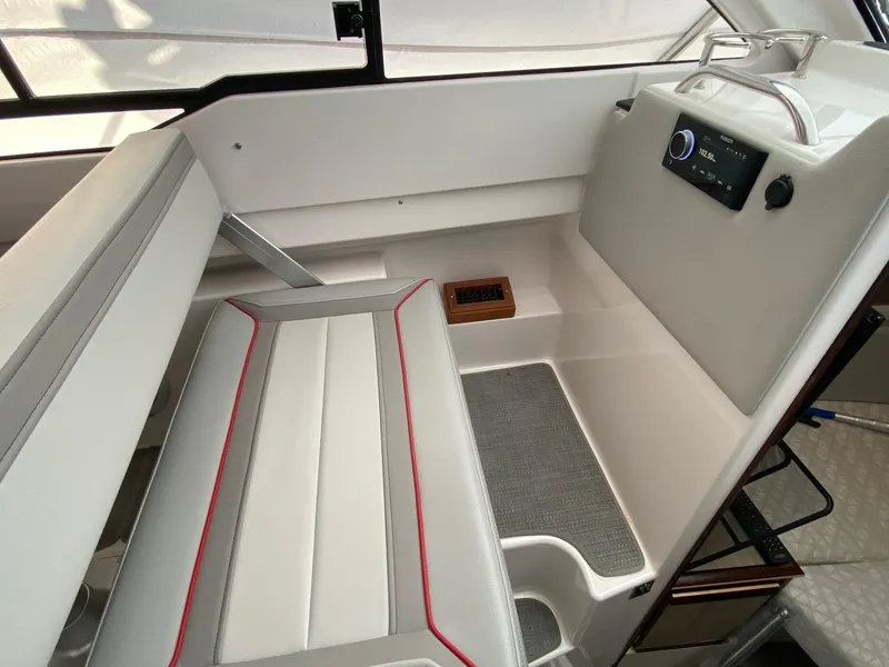 Slide: The Image of 2024 Solara S-250 C boat interior with white and gray seating, control panel, and window. - 9
