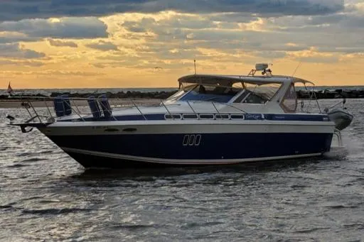 Slide: The Image of 1988 Chris-Craft 412 boat cruising on water at sunset. - 10
