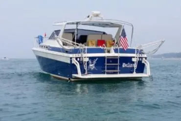 Slide: The Image of 1988 Chris-Craft 412 boat on water, rear view with American flag. - 11