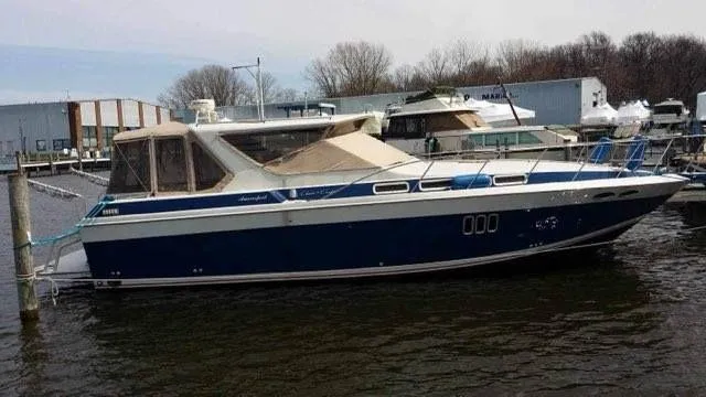 Slide: The Image of 1988 Chris-Craft 412 yacht docked at marina, blue and white exterior. - 17