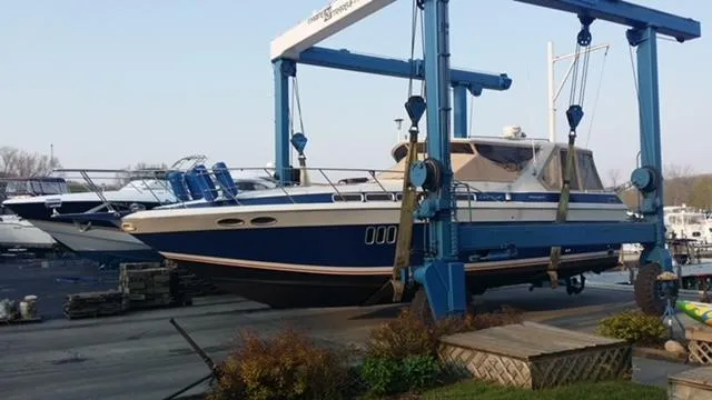 Slide: The Image of 1988 Chris-Craft 412 boat being lifted at a marina. - 2