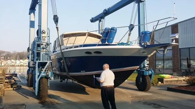 Slide: The Image of 1988 Chris-Craft 412 yacht being lifted by a boat hoist for maintenance. - 3