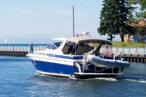 Slide: The Image of 1988 Chris-Craft 412 boat cruising on a sunny day near a dock. - 9