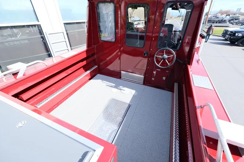 Slide: The Image of 2024 Hewescraft 220 Ocean Pro ET HT boat interior, red exterior, spacious deck, and steering wheel. - 4