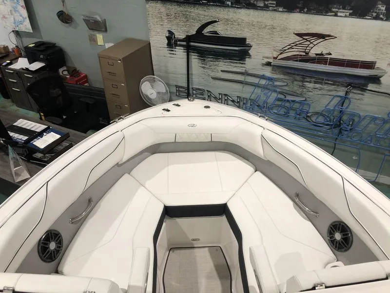 Slide: The Image of 2024 Regal LS2 boat interior with white seating and speakers, displayed indoors. - 8