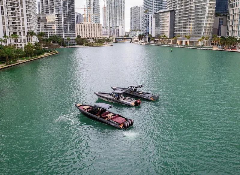 Slide: The Image of Three Skipper-BSK 38 boats cruising in a city canal, surrounded by modern high-rise buildings. - 13