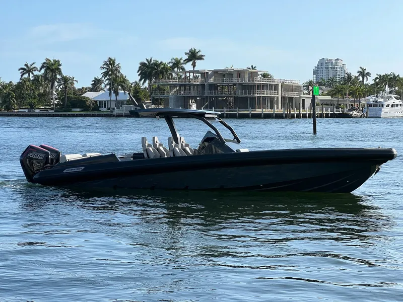 Slide: The Image of 2024 Skipper-BSK 38 boat cruising on a sunny day near waterfront homes. - 0